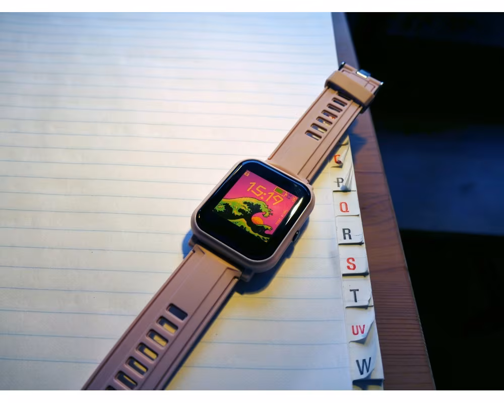 A Bangle.js 2 with a colour clock face