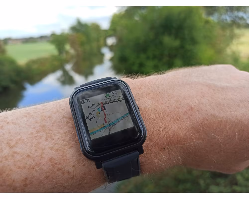 A Bangle.js 2 on the wrist showing a map